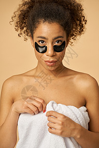 淋浴后用白毛巾裹住的年轻女子的肖像 加上在蜜蜂背景上隔绝的黑色眼罩下涂黑图片