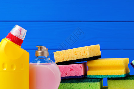 各种蓝色木制背景的清洁用品以及化学品服务物品洗涤剂刷子手套液体家务海绵地面图片