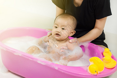 婴儿在浴缸里洗澡和玩泡沫泡泡洗发水洗涤浴室肥皂身体卫生微笑快乐女孩孩子图片