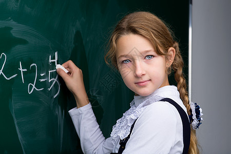 课堂上在黑板上写字的女学生学生科学学校智力数学孩子们背包女孩学习木板图片