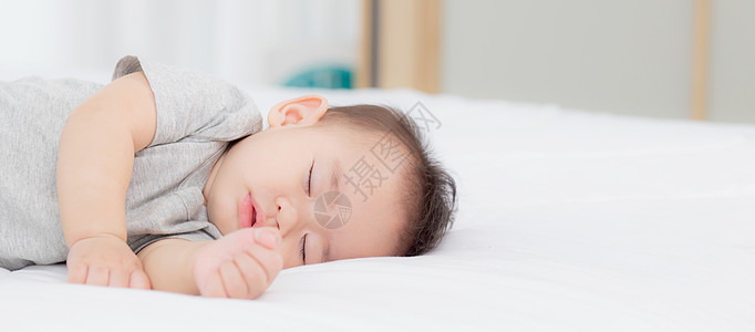 睡在家里卧室床上的亚洲小女婴的肖像 新生儿在舒适和放松的情况下打盹 睡前的婴儿纯真 快乐的幼儿可爱 孩子的成长和情感 在室内闲暇图片