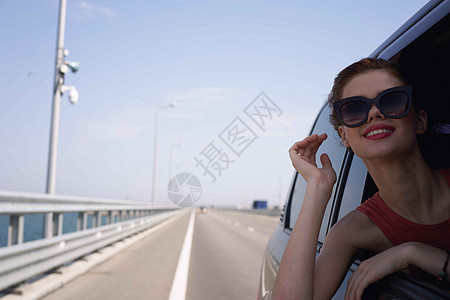 一个女人开车在路上 望着窗外的一辆车驾驶女士太阳镜汽车旅行假期晴天蓝色女性车辆图片