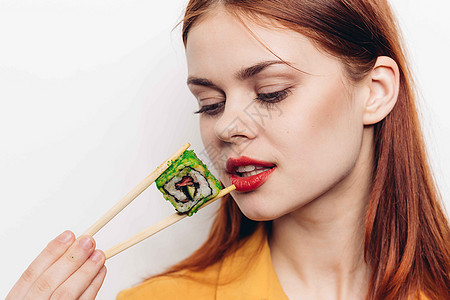 开心的红头发女人 筷子寿司日本菜摄影服务女性舌头食物正方形海鲜美丽工作室黄瓜图片