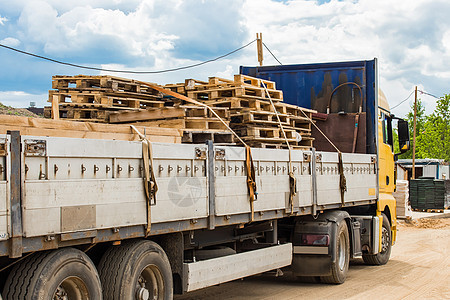 在建筑工地运输木制货盘 工业货运或木材货物的卡车 运货物流工厂送货盒子工作包装仓库木头贸易商品图片