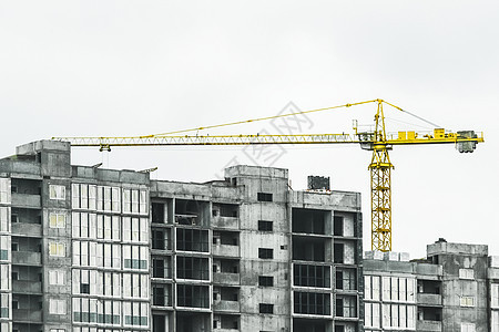塔式黄色建筑起重机在施工现场建造新的混凝土和水泥城市建筑房子工程技术工作摩天大楼进步建筑物建筑学天空脚手架图片