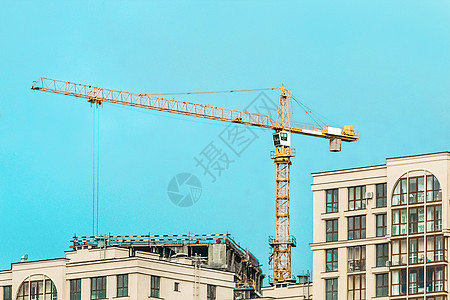 建筑工地上的塔式工业起重机 城市建筑的建筑发展和工作水泥项目脚手架商业建筑物财产技术房子生长公寓图片