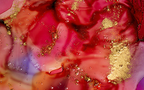 深红色水彩墨迹 在透明液体下 有气泡和金质微粒图片