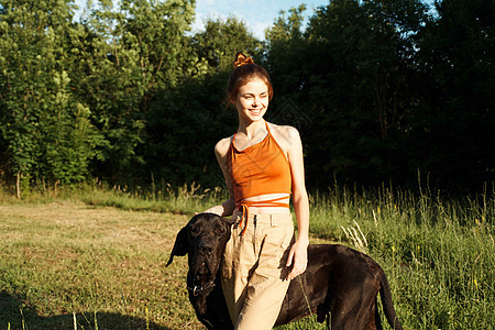 快乐的女人和玩自然游戏的狗友情动物猎犬家庭农村宠物女孩阳光晴天小狗日落图片