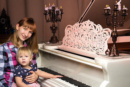 母亲与一个小孩在白色钢琴旁边父母钢琴家成人女儿学习乐器音乐家教学乐趣音乐图片