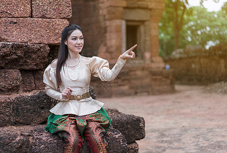 穿着泰国传统礼服的美丽女性指着寺庙裙子成人戏服幸福文化微笑公园历史女孩图片
