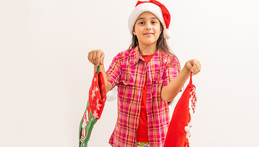 可爱笑笑的小孩女孩 穿着红礼服检查她的圣诞丝袜乐趣快乐帽子孩子假期家庭惊喜传统微笑展示图片