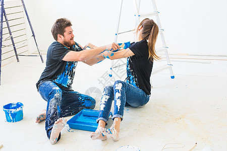 重新装配 颜色 翻新和人的概念一对夫妇要油漆墙壁 他们混合着颜色 玩得开心男人滚筒女士装潢绘画维修公寓手套房间夫妻背景图片