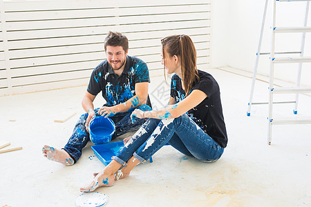 重新装配 颜色 翻新和人的概念一对夫妇要油漆墙壁 他们混合了颜色幸福房间团队男性蓝色滚筒成人维修公寓女性背景图片