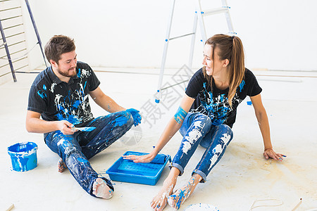 重新装配 颜色 翻新和人的概念一对夫妇要油漆墙壁 他们混合着颜色 玩得开心房间刷子绘画夫妻乐趣男性女性蓝色家庭男人背景图片