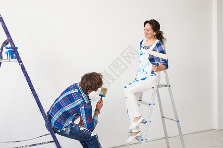 团队工作 翻新和修理概念     在梯子上涂满油漆的男女女孩公寓检修艺术工具维修辛劳设计师改造家庭图片