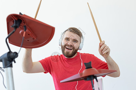 鼓手 鼓 音乐和人的概念  年轻的鼓手在白色房间里演奏玩家红色胡须音乐家铙钹岩石衬衫微笑韵律演员图片