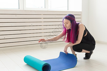 穿着彩色头发折叠体操垫和体育课课后运动垫的苗条女孩 瑜伽和小便的概念动机身体运动女性耐力有氧运动活动教练运动员健身房图片