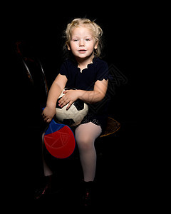 小女孩带着一个足球球 在黑色背景上教育孩子们女孩女性白色乐趣玩家衣服手势黑发图片