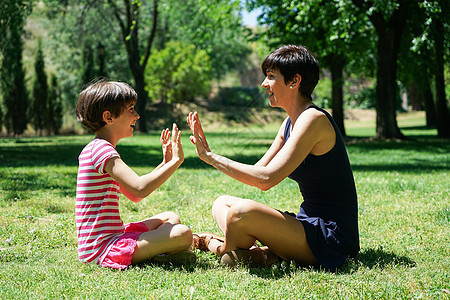 母亲和女儿在城市公园玩手牵手微笑乐趣单亲妈妈妈妈小姑娘孩子童年两个人棕榈成人图片