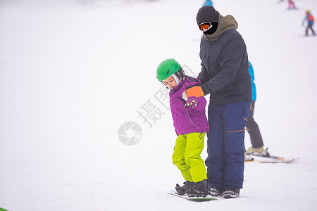 小可爱女孩滑雪 在滑雪胜地 阳光明媚的冬天女性孩子头盔活动木板运动员假期快乐运动乐趣图片