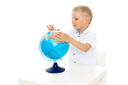 一个小男孩正在研究一个地球的地理学科学瞳孔男生童年教育知识学校旅行男性课堂图片