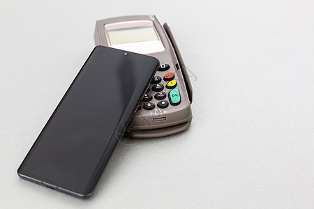 使用移动电话支付费用给NFC的客户电话读者零售购物技术交易通信店铺卡片机器图片