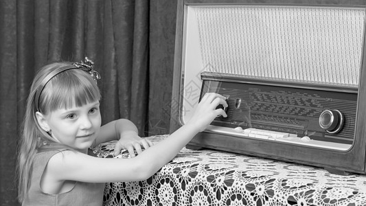 女孩在旧收音机上打开音量键盘扬声器幸福快乐工作室体积卷曲调频童年女儿控制图片
