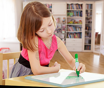 小女孩在桌边画着标码的画幸福童年女性幼儿园卧室乐趣学校学生家具广告牌图片