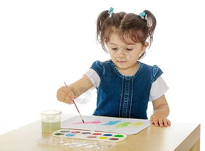 小姑娘在桌子上涂着水彩画创造力绘画学习孩子乐趣孩子们房间幼儿园教育学校图片