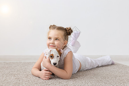 人 儿童和宠物的概念  小女孩躺在地板上 带着可爱的小狗杰克罗素梗犬婴儿过敏彩虹寂寞孩子毛皮投标朋友地毯孩子们图片