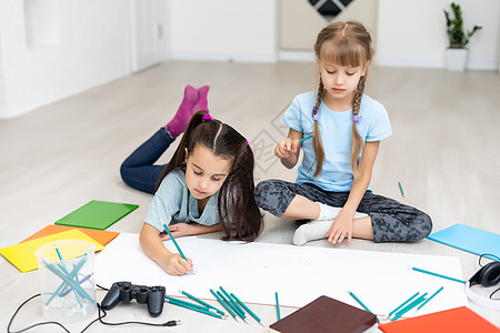 可爱的孩子躺在家里的地板上时在画画和微笑教育闲暇说谎染色儿子兄弟孩子们乐趣姐姐女孩图片