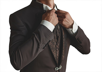 一个身穿白衬衫和带图案的棕色时尚西装的男人用手在白色背景上拉直衣领 与世隔绝奢华配饰衣服成人套装领带生活商业博客人士图片