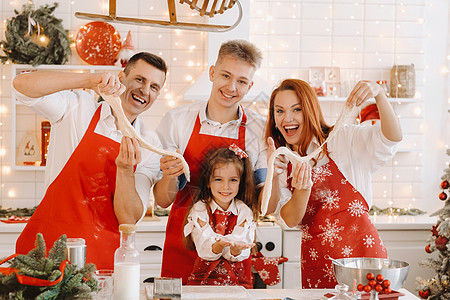 家人站在厨房里 在圣诞节前把钱放在他们的手中 Y 我房子面团小姑娘母亲男人帮助微笑女士烹饪面粉图片