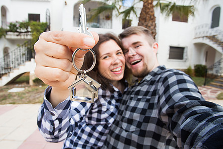 财产 房地产和公寓概念  快乐风趣的年轻夫妇展示他们新房的钥匙投资买家家庭女性幸福微笑销售贷款男人男性图片