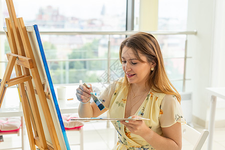 艺术学校 创意和休闲概念  女学生或年轻女艺术家在工作室用画架 调色板和画笔绘画作坊美术工艺爱好学习学生创造力成人教育画家图片