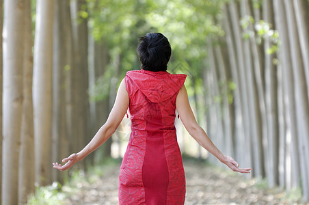 穿红衣服 在森林里冥想的女人红色林地地面木材叶子兜帽季节性小路闲暇呼吸图片