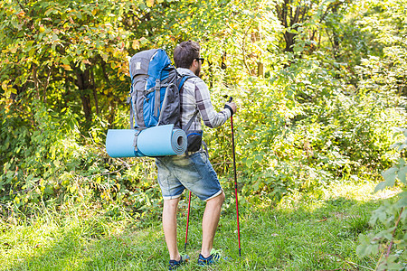 远足 旅游和自然概念 — 背着背包站在森林背景上的年轻旅行者图片