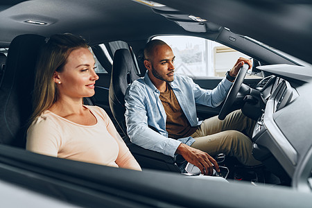 快乐的年轻夫妇在一辆车里四处看 他们准备在汽车店买新车幸福家庭测试零售运输司机消费者买家男性店铺图片