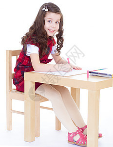 小女孩坐在桌边画画时用彩色铅笔学校水平桌子工艺幼儿园孩子蜡笔女孩黑发女性图片