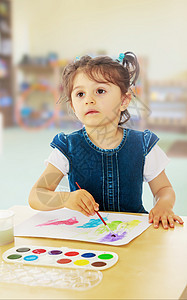 小姑娘在桌子上涂着水彩画房间孩子家具幼儿园绘画卧室房子艺术材料创造力图片