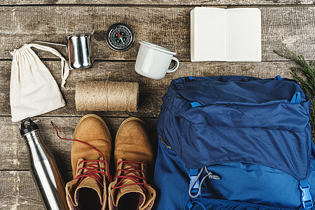 木制背景 顶视图的背包和徒步旅行设备生活项目假期冒险地面运动罗盘旅游皮革齿轮图片