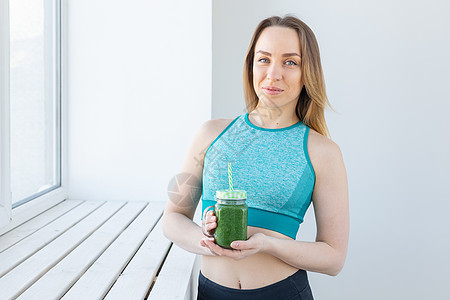 健康 饮食 脱毒和体重减肥概念     参加运动的年轻女子 带绿色冰淇淋排毒微笑营养液体活力蔬菜水果女性福利果汁图片