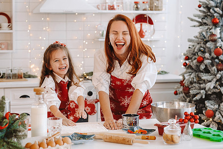 新年厨房的妈妈和女儿 一起为圣诞饼干准备点钱吃吧房子女孩烹饪桌子厨师喜悦面粉食物围裙午餐图片