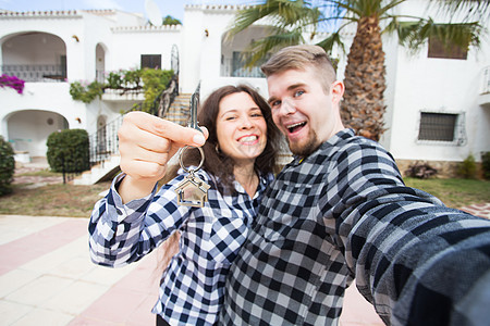 房地产和财产概念  幸福的夫妻拿着新家和微型房屋的钥匙建筑公寓快乐房子贷款女士男人男性乐趣投资图片