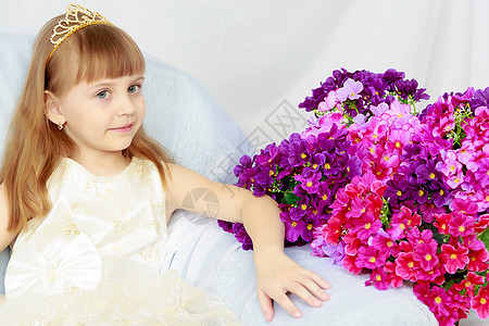 女孩坐在一束花的旁边公主冒充幸福微笑快乐卷曲植物群工作室植物花瓣图片
