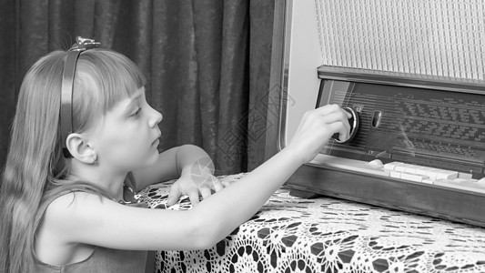 女孩在旧收音机上打开音量键盘女性幸福频率卷曲扬声器快乐女儿公主调频拨号图片
