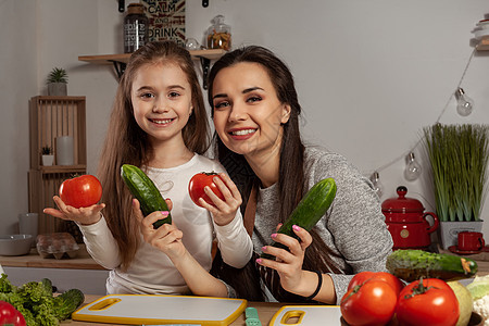 母亲和女儿正在做蔬菜沙拉 在厨房里玩得开心呢桌子货架童年孩子木板黑发家庭黄瓜用具菜花图片