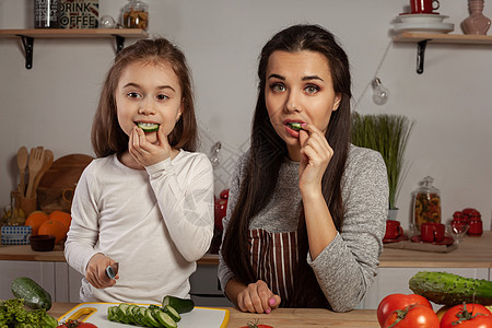 母亲和女儿正在做蔬菜沙拉 在厨房里玩得开心呢菜花桌子烹饪营养食谱货架妈妈女孩孩子们黄瓜图片