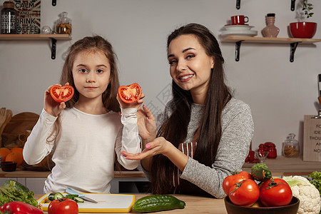 母亲和女儿正在做蔬菜沙拉 在厨房里玩得开心呢灯泡妈妈食谱女孩黄瓜菜花家庭烹饪孩子父母图片