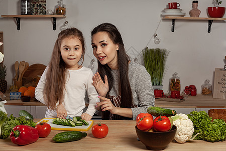 母亲和女儿正在做蔬菜沙拉 在厨房里玩得开心呢胡椒童年食物黄瓜父母木板成人用具女士黑发图片